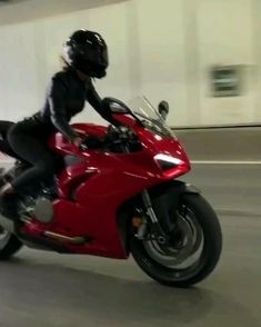 a person on a red motorcycle in a parking garage