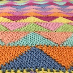 the colorful knitted blanket is on display