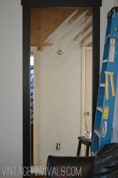 a ladder is next to a white door in a room that has been painted black