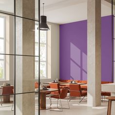 an empty restaurant with purple walls and orange chairs