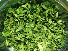 a metal bowl filled with green leafy vegetables