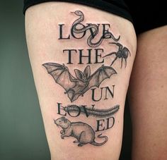 a black and white tattoo on the leg of a woman's thigh that reads, love the un - loved