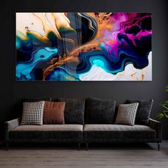 an abstract painting hangs on the wall above a couch in a living room with black walls