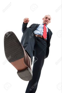 a man in a suit and tie is jumping up into the air with his feet