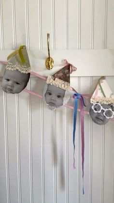 three hats hanging on a wall with ribbons and clips attached to it's sides