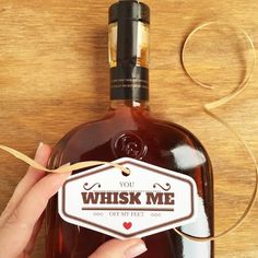 a person holding a bottle of whiskey with a tag on the label that says, you whisk me