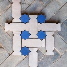 a blue and white tile pattern on the ground with one piece cut out to look like an interlocking puzzle