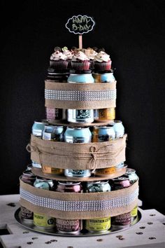 a tiered cake made out of cupcakes and cans