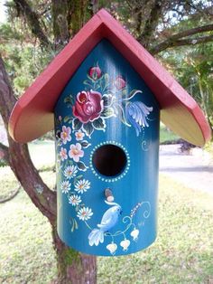 a blue birdhouse with flowers painted on it