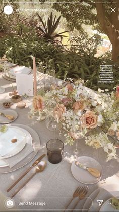 the table is set with flowers and silverware