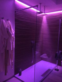 a bathroom with a purple light in the shower