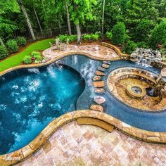 an aerial view of a backyard with a pool and hot tub in the middle of it