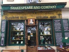 two people standing in front of shakespeare and company