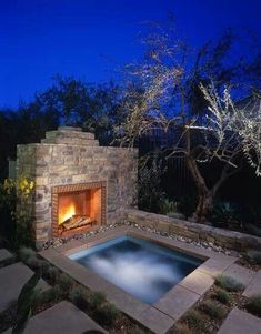 an outdoor fireplace in the middle of a backyard