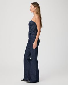 The must have one-piece of the season. Inspired by our Leenah wide leg silhouette, this strapless jumpsuit is crafted from super soft dark wash denim with a hint of stretch for comfort and features silver front buttons, elastic at the back, and light boning in the bodice. The Sansa Jumpsuit pairs perfectly with boots, heels, or flats. | Sansa Jumpsuit - Calix Blue | Size 6 Wide Leg Denim Strapless Jumpsuit, Strapless Wide Leg Denim Jumpsuit, Chic Strapless Denim Jumpsuits And Rompers, Chic Dark Wash Wide Leg Denim Jumpsuit, Chic High Rise Strapless Jumpsuit, Fitted Wide-leg Dark Wash Jumpsuits And Rompers, Dark Wash Fitted Wide Leg Jumpsuits And Rompers, Fitted Dark Wash Wide Leg Jumpsuits And Rompers, Fitted Wide Leg Dark Wash Jumpsuit