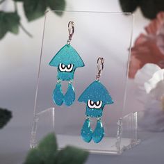 Introducing our stunning Swimming Squid Acrylic Earrings, inspired by the vibrant world of Splatoon! These delightful dangle earrings feature a unique jelly shimmer finish that adds a playful touch to any outfit. Lightweight and comfortable, they are perfect for everyday wear or a fun day out. Whether you're a fan of swimming in ink or simply love eye-catching accessories, these earrings will make a splash in your jewelry collection. Treat yourself or surprise a friend with these enchanting earr Blue Quirky Earrings As Gift, Quirky Blue Earrings For Gift, Quirky Blue Jewelry For Gifts, Quirky Blue Jewelry For Gift, Playful Resin Dangle Earrings, Quirky Hypoallergenic Dangle Earrings, Fun Blue Drop Earrings, Playful Nickel-free Resin Earrings, Fun Resin Earrings For Gifts