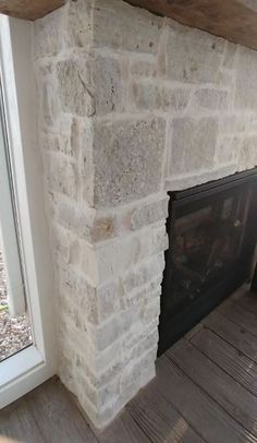 a stone fireplace with a wooden mantle and window