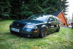 a black car parked on top of a lush green field