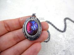 "This locket is exquisite! The focal point of this necklace is the glass cabochon which has been made in the style of a Mexican Opal also known as Dragon's Breath (made from glass not a gemstone). Each stone is handmade which means no two stones will be alike. With each slight turn, the colors shift from deep scarlet red to lightening strikes of blues! What is a Mexican Opal? Mexican Opal, also known as Dragon's Breath, is a collector's nickname for man-made stones that are made of glass and mix Mystical Multicolor Jewelry For Gift, Handmade Mystical Multicolor Jewelry, Iridescent Metal Necklace Gift, Multicolor Oxidized Jewelry As Gift, Multicolor Oxidized Finish Jewelry As Gift, Mystical Oxidized Necklace For Gift, Mystical Oxidized Finish Necklace For Gift, Red Necklace With Oxidized Finish For Gift, Red Oxidized Finish Necklace For Gift