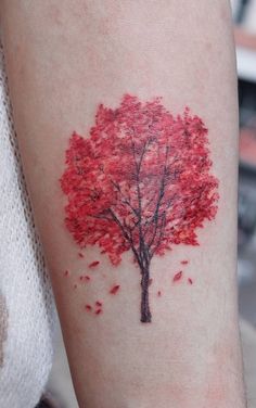 a red tree tattoo on the arm