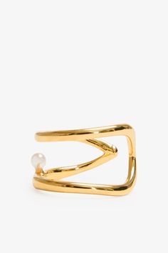 Our Mandy Abstract Ring is an emblem of elegance. Handcrafted from brass with 18k gold plating, this asymmetrical ring coils twice around your finger and presents a luminous faux pearl between her bands. Delicate and expressive, modern and timeless, Mandy raises the standard for your capsule jewelry box. Each ring includes a Marcella-branded vegan leather travel case for safe storage and easy travel.[SPLIT] Available in one size. Approximately .75” (2 cm) in height, and 1" (2.25 cm) in width. 18 Gold Pearl Open Ring, Gold Open Pearl Ring, Elegant Metal Pearl Open Ring, Elegant Pearl Open Ring In Metal, Elegant Open Metal Pearl Ring, Gold Plated Open Pearl Ring, Capsule Jewelry, Abstract Ring, Asymmetrical Ring