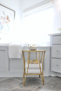 a bathroom with white and gold accents