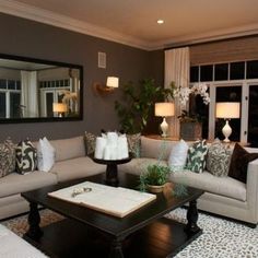 a living room with couches, tables and lamps on the floor in front of windows