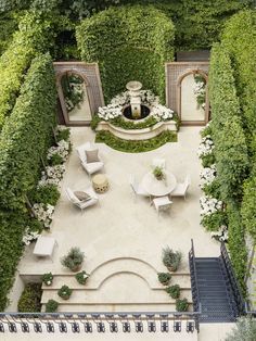 an aerial view of a patio with chairs and tables surrounded by greenery, shrubs and trees