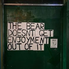 a green door with a sign that says the bear doesn't get enjoyment out of it