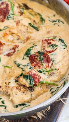 a pan filled with cheese and spinach covered in sauce on top of a cutting board