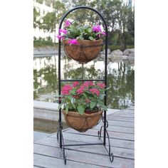 two baskets with flowers are sitting on a stand