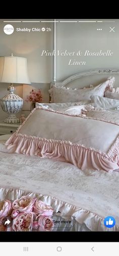 a white bed topped with pink flowers and pillows