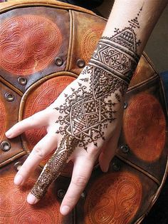 a woman's hand is decorated with hennap and intricate designs on it