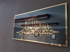 the reflection of an arabic calligraphy on a mirror in a building's lobby