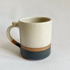 a white and blue coffee cup sitting on top of a table