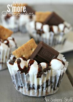 chocolate and marshmallow cupcakes with graham crackers in the middle on a wooden table