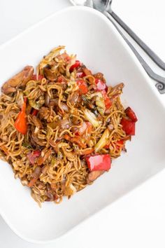 a white plate topped with noodles and vegetables