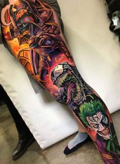 a man's leg with tattoos on it and an image of the joker, batgirl