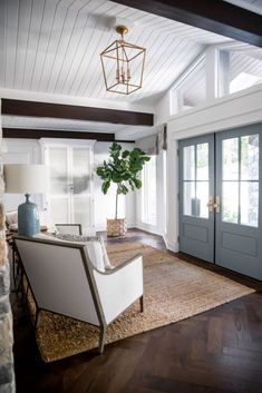 a living room filled with furniture and a large rug on top of a hard wood floor