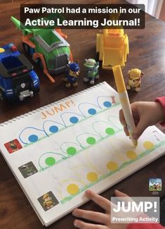 a child's hand writing on a paper with toy vehicles in the background and text that reads paw patrol had a mission in our active learning journal