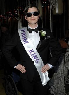 a man in a tuxedo is posing for the camera