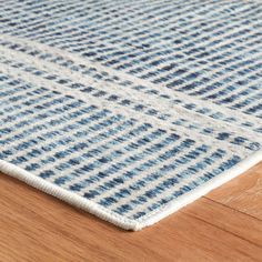 a blue and white rug on top of a wooden floor next to a wood floor