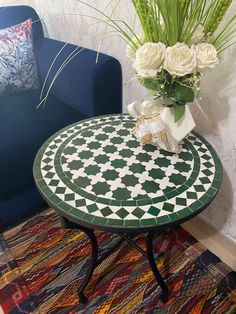 a small table with flowers on it next to a blue couch