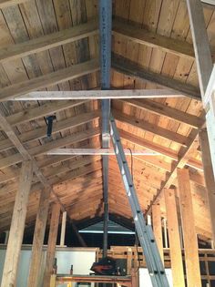 the inside of a building being constructed with wooden beams and metal piping on the ceiling