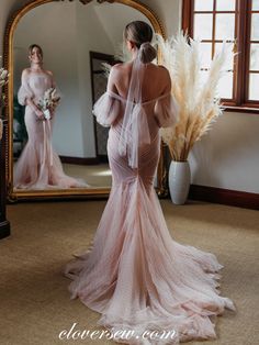 a woman in a wedding dress is looking at herself in the mirror with her reflection