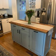 a kitchen with an island in the middle of it and stainless steel appliances on either side