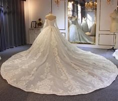 a wedding dress is on display in front of a mirror and mannequins