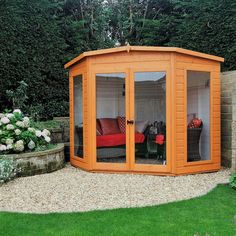 a small wooden shed with glass doors on the inside and outside, in a garden setting