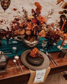 the table is set with flowers, candles and other items for an outdoor wedding reception