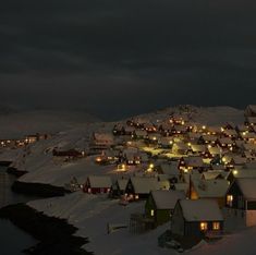 a snowy village with lights on at night